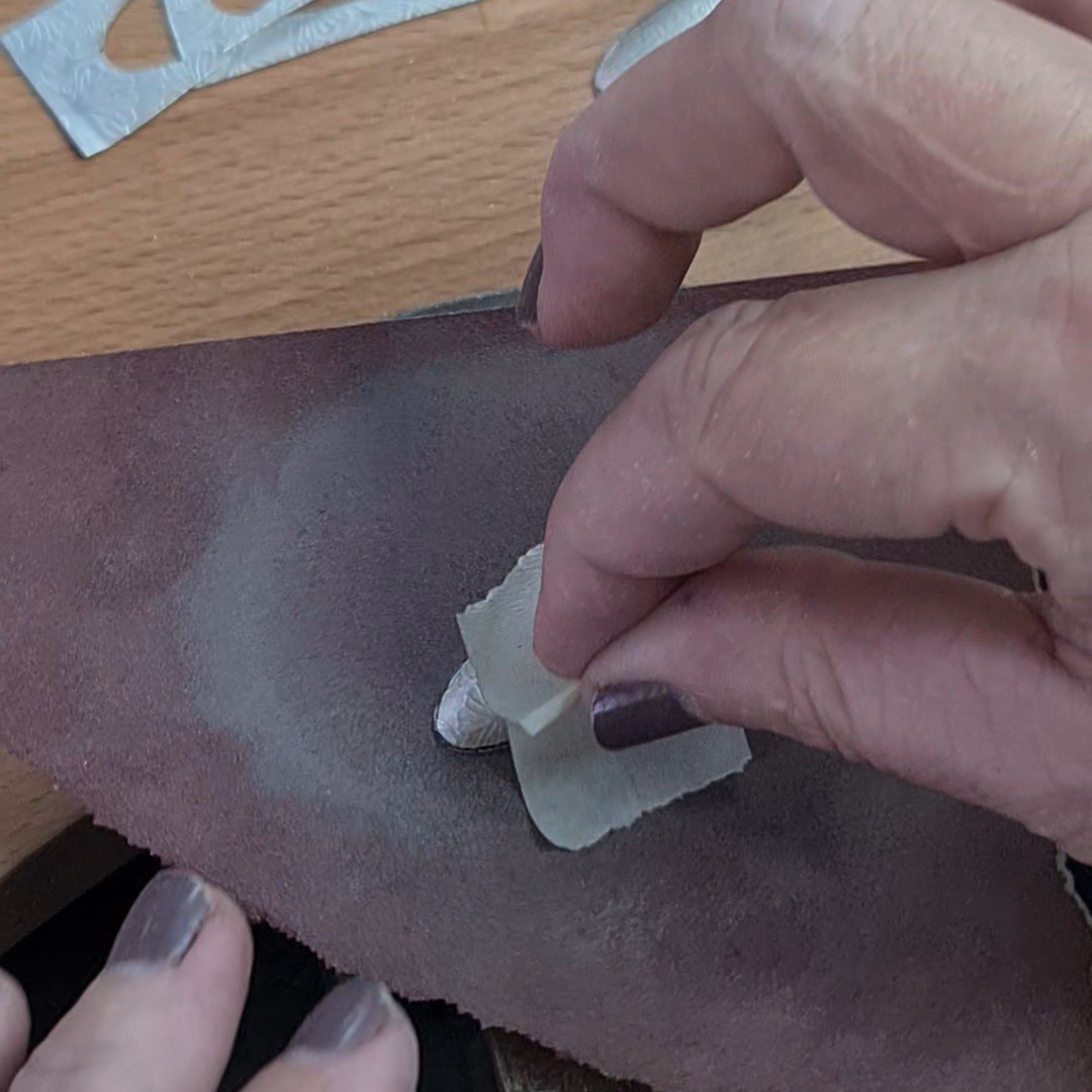 image shows the rim of a silver oval being sanded flat.